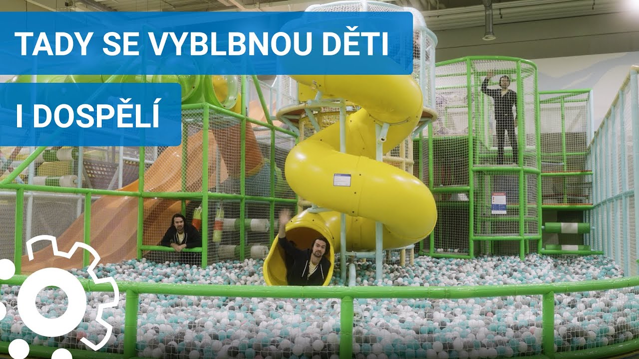 Dospělí i děti si hrají na skluzavkách a v suchém bazénu s míčky v zábavním centru