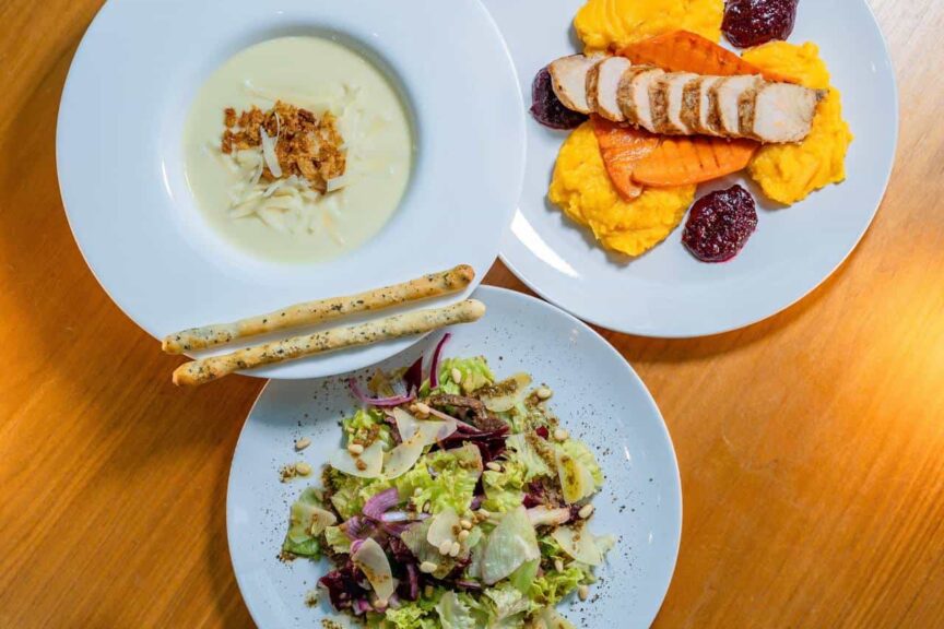 Krémová polévka s tyčinkami, salát s listovou zeleninou a grilovaná kuřecí prsa s batátovým pyré a brusinkovou omáčkou